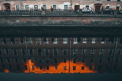 Old multistage building facade reflecting in urban canal