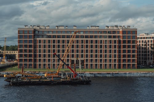 Modern multistage building exterior against crane on pontoon
