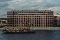 Modern multistage building exterior against crane on pontoon