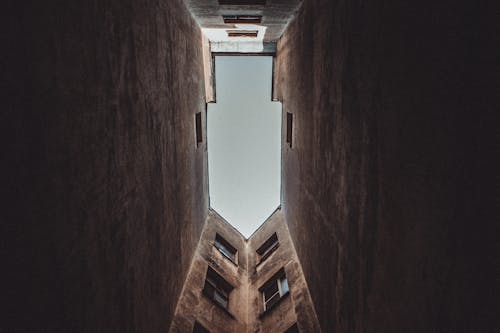 Low angle of aged multistage house with windows and weathered walls in city in daytime