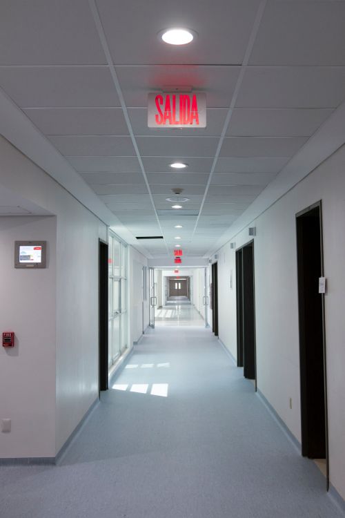 Free Empty hospital corridor with 'Salida' exit sign, featuring clean design and bright lighting. Stock Photo