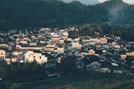 Old residential houses in green mountains with haze
