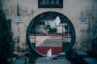 Round hole in old house wall with rough court
