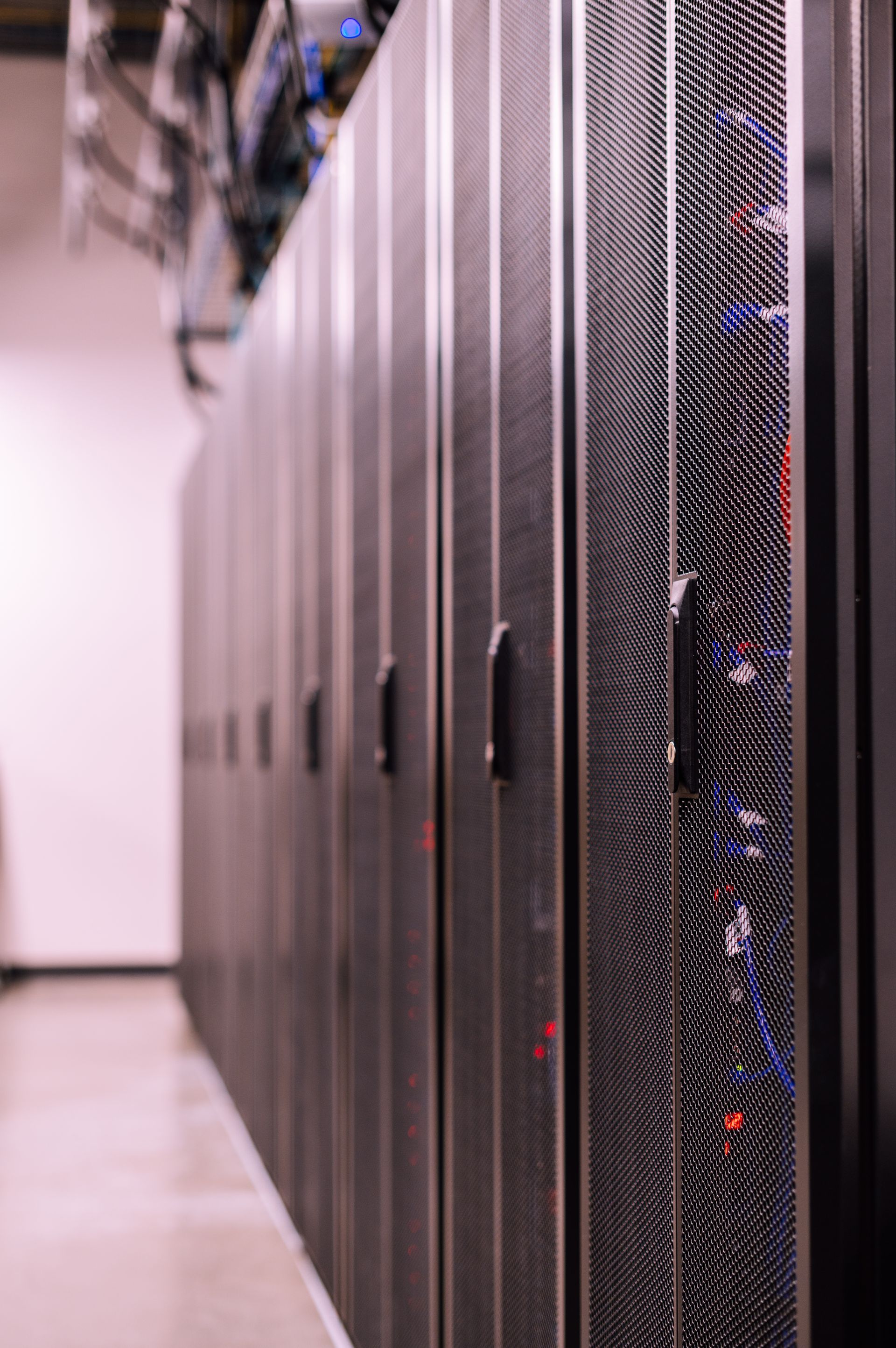 Data center server room with rows of illuminated racks — AI infrastructure frame for Merid