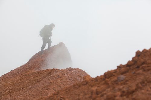 Free A lone hiker traverses a foggy mountain ridge in Kamchatka, Russia, showcasing rugged adventure. Stock Photo