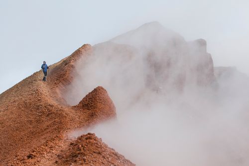 Free Solitary hiker on a foggy mountain ridge in Kamchatka showcasing adventure and nature. Stock Photo