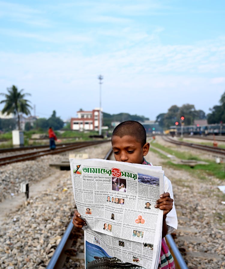 Boy In White Shirt Reading Newspaper