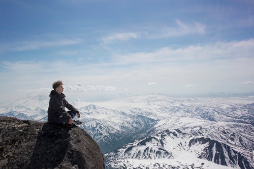 Man in Black Jacket Sitting on a Cliff 