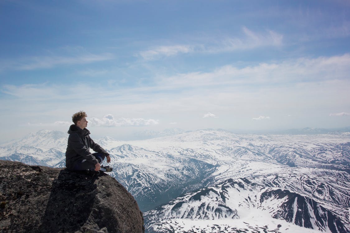 Man in Black Jacket Sitting on a Cliff 