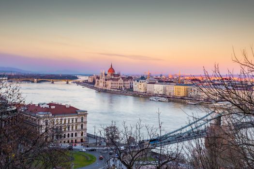 A breathtaking aerial view of Budapest, showcasing the Danube River and iconic Hungarian Parliament at sunset.