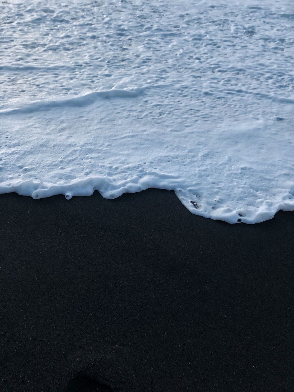 Close-up of waves meeting the volcanic black sand of Vik Beach in Iceland.. close, waves, meeting