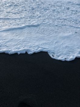 Close-up of waves meeting the volcanic black sand of Vik Beach in Iceland.. close, waves, meeting