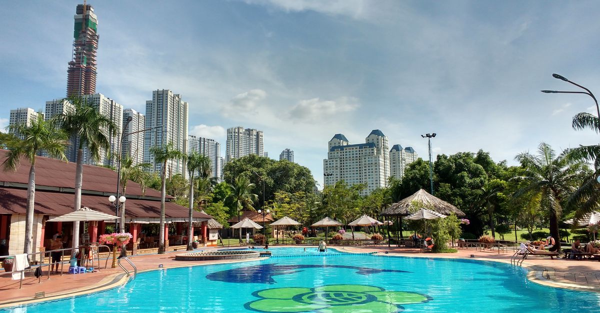 Luxury hotel pool overlooking Ho Chi Minh City skyline at sunset