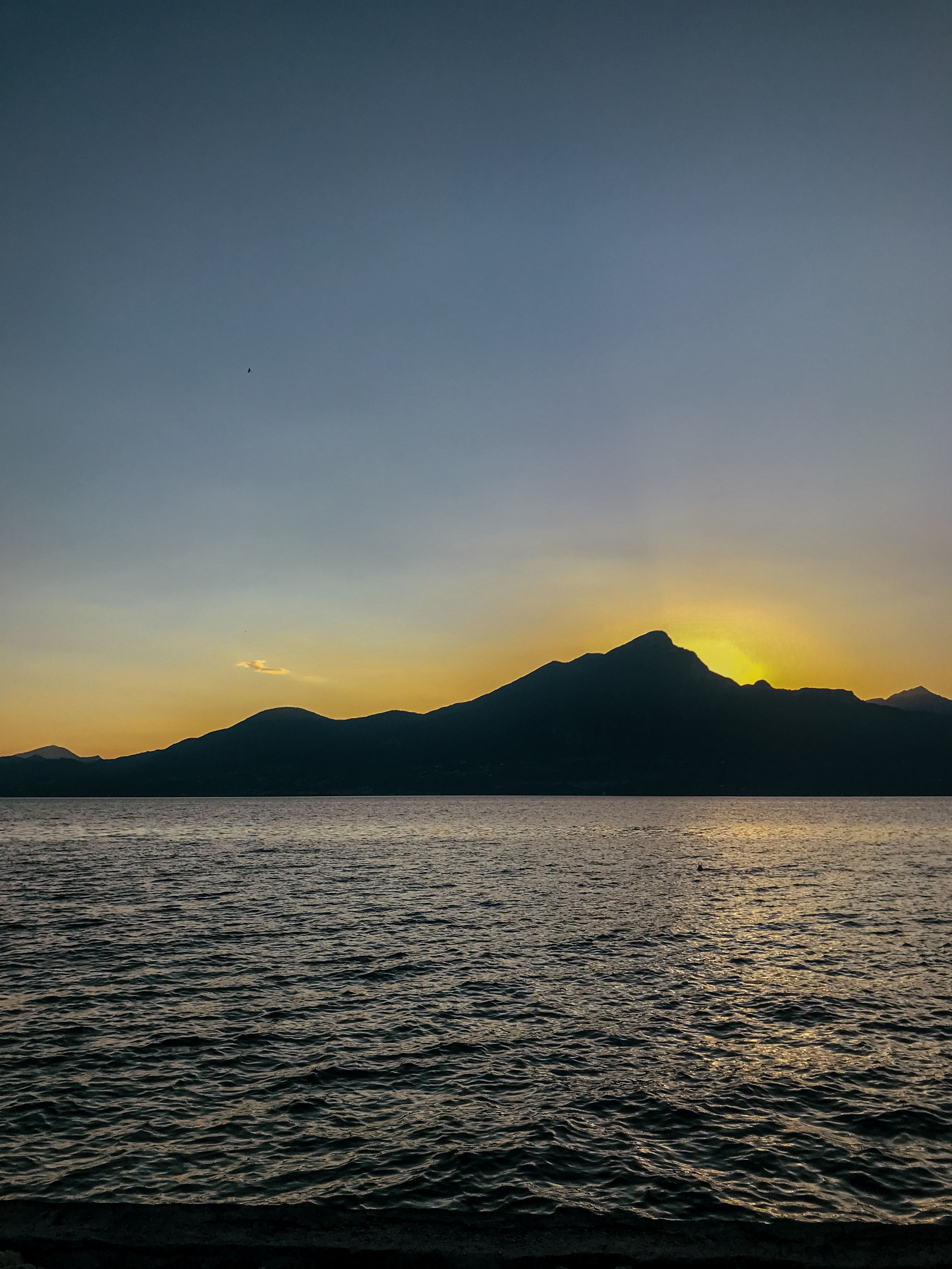 Silhouette of Mountain Near Body of Water during Sunset · Free Stock Photo