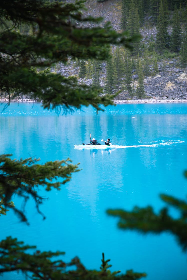 People Floating In Boat On Calm Lake