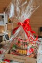 Various delicious food served in gift wrapping with red ribbon on table at daylight