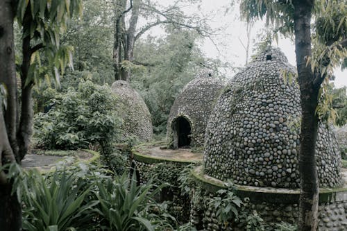 Exterior of aged stone meditation caves located on territory of Beatles Ashram in lush green tropical garden in India