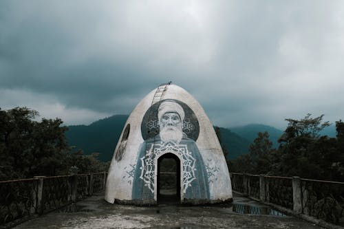 산악 계곡의 안개 낀 하늘을 배경으로 전통적인 돔형 명상 동굴