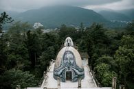 在印度多云天空下，郁郁葱葱的绿色雨林里，佛教冥想屋的屋顶上，有一个涂鸦的小圆顶洞穴