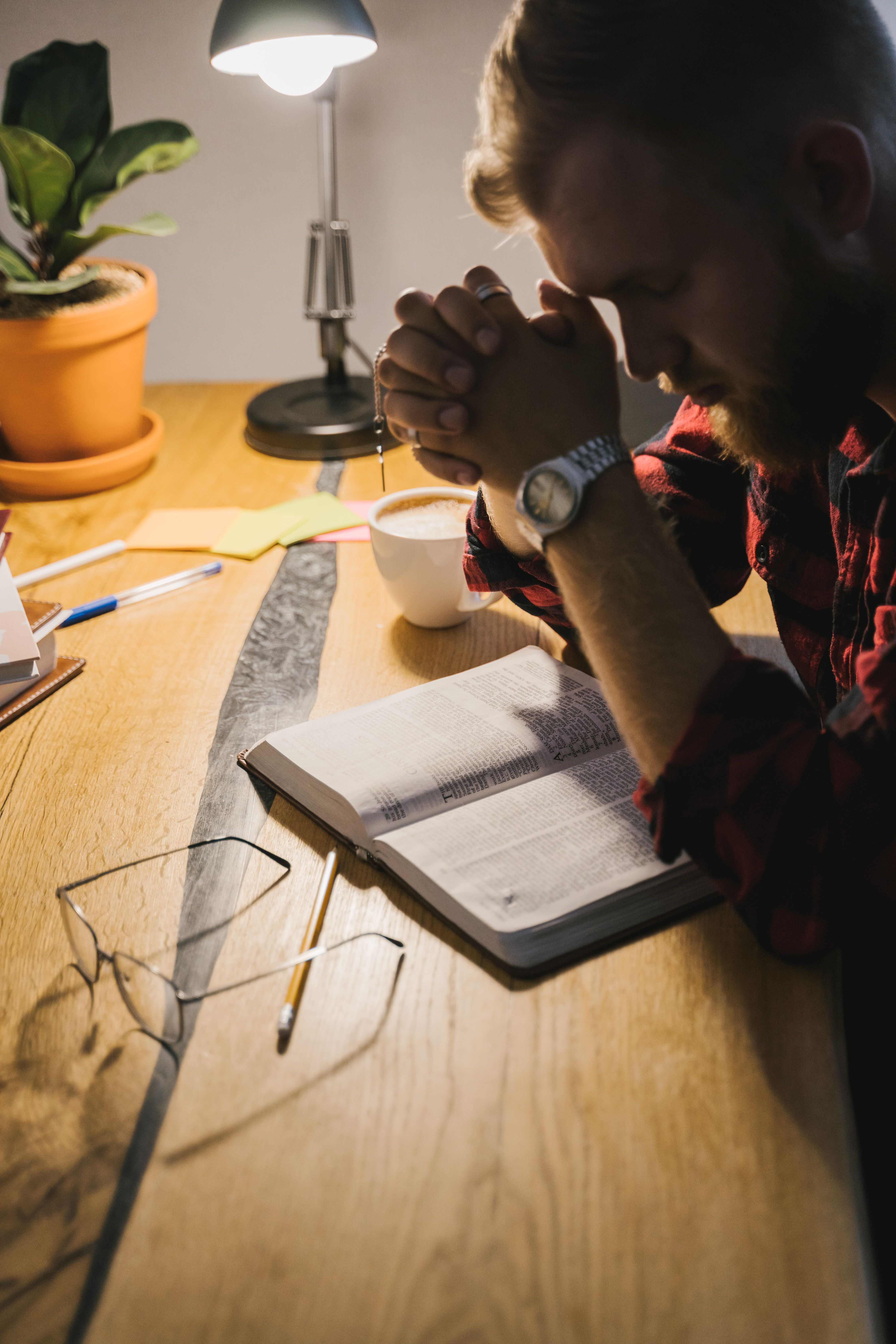 A person holding an open Bible in a quiet, prayerful moment