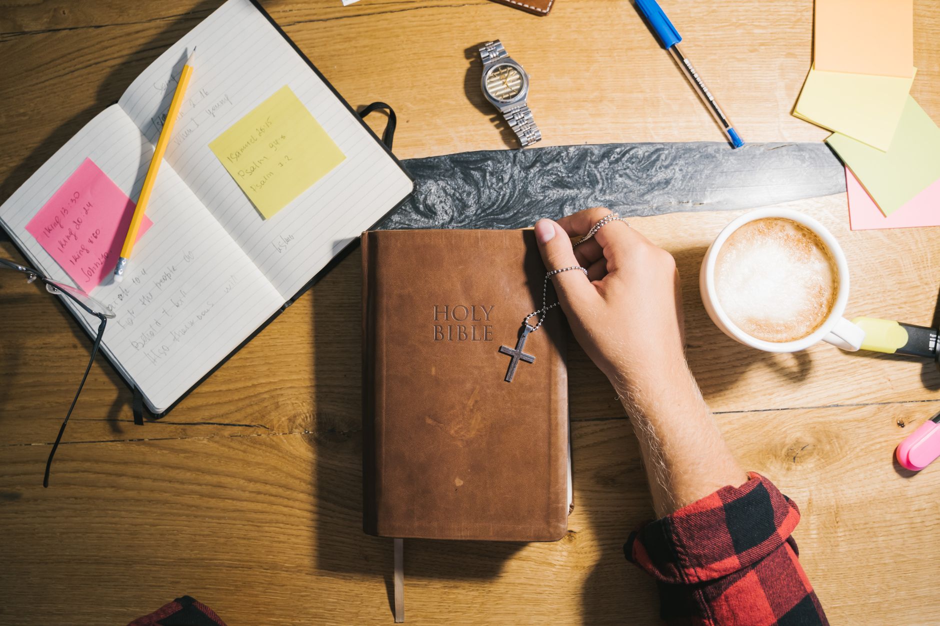 Top view of a Bible study setup with coffee, notes, and wooden table