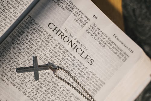 Free Grayscale Photo of a Holy Bible with a Cross Pendant Stock Photo