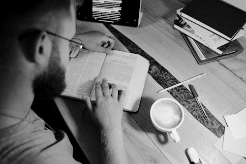 Free Grayscale Photo of a Person Reading a Bible Stock Photo