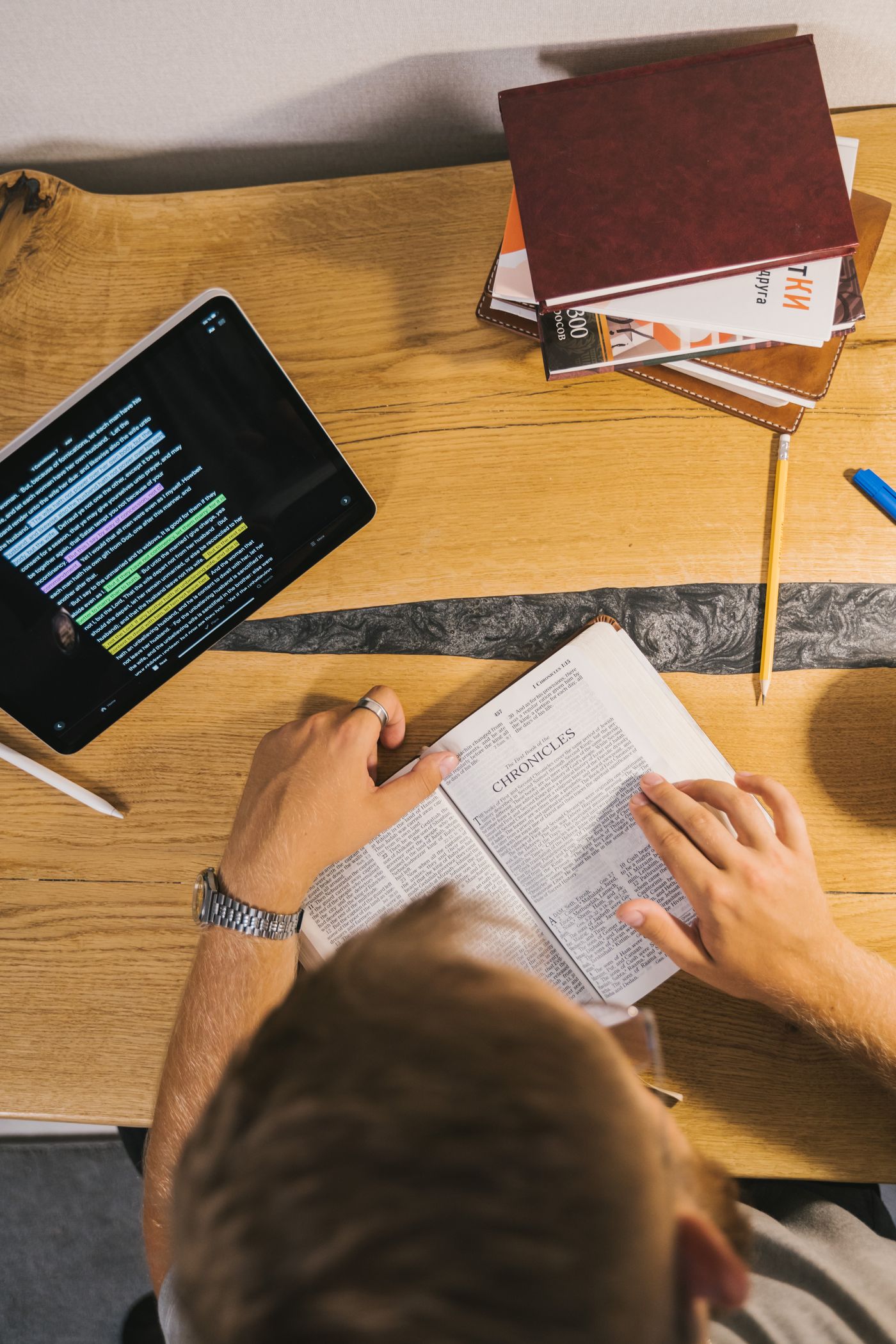 A person studying an open Bible with notes at a desk