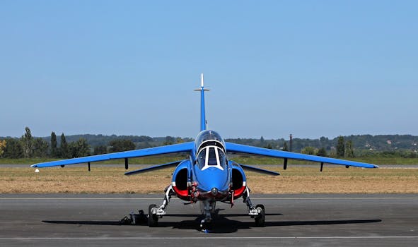 A vibrant blue jet aircraft parked on the runway with a clear sky backdrop, perfect for transportation themes.
