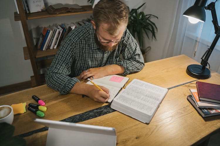 A Man Writing On The Notebook