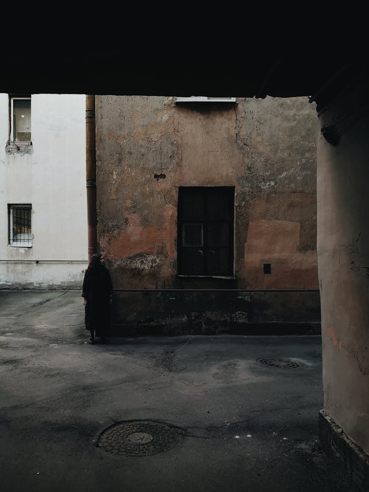 A Woman Standing Outside The Old Building 