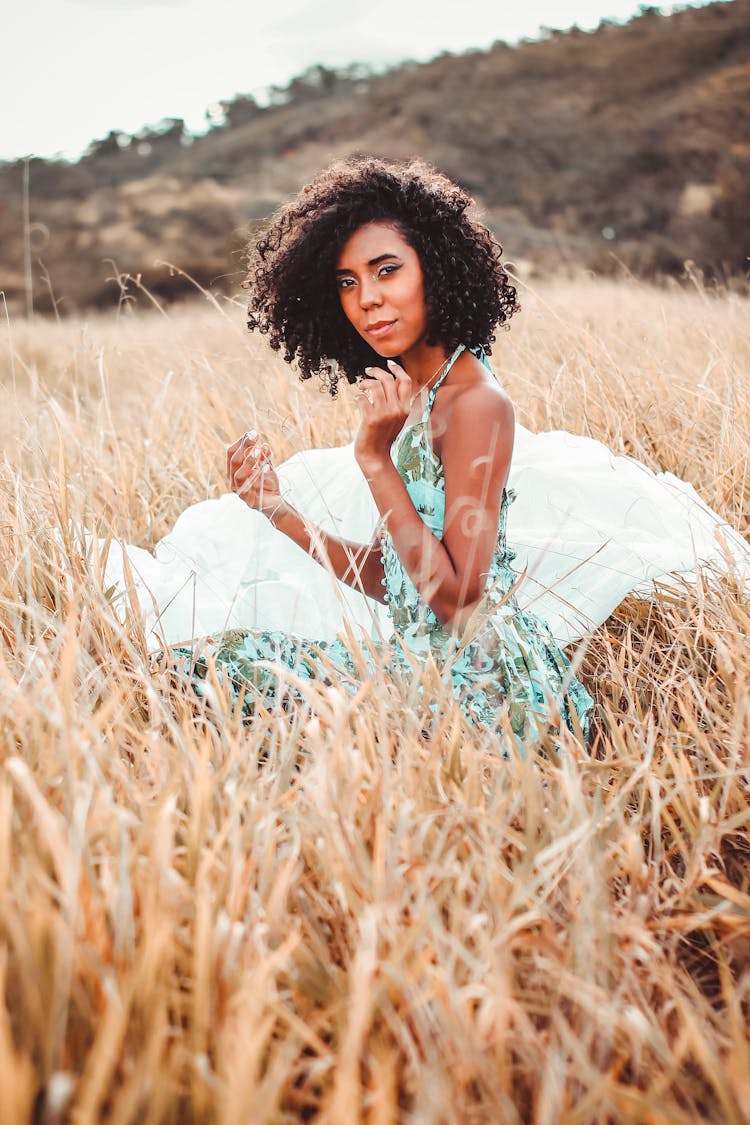 Black Curly Haired Woman In Grassy Field