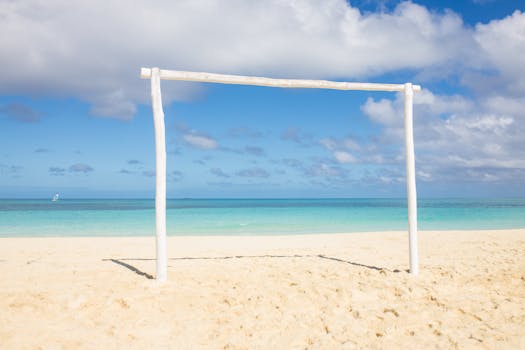 A tranquil beach setting with a white wooden frame against a vibrant sea and sky backdrop.