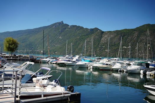 Beautiful marina with boats docked at Aix-les-Bains, France against mountainous backdrop.