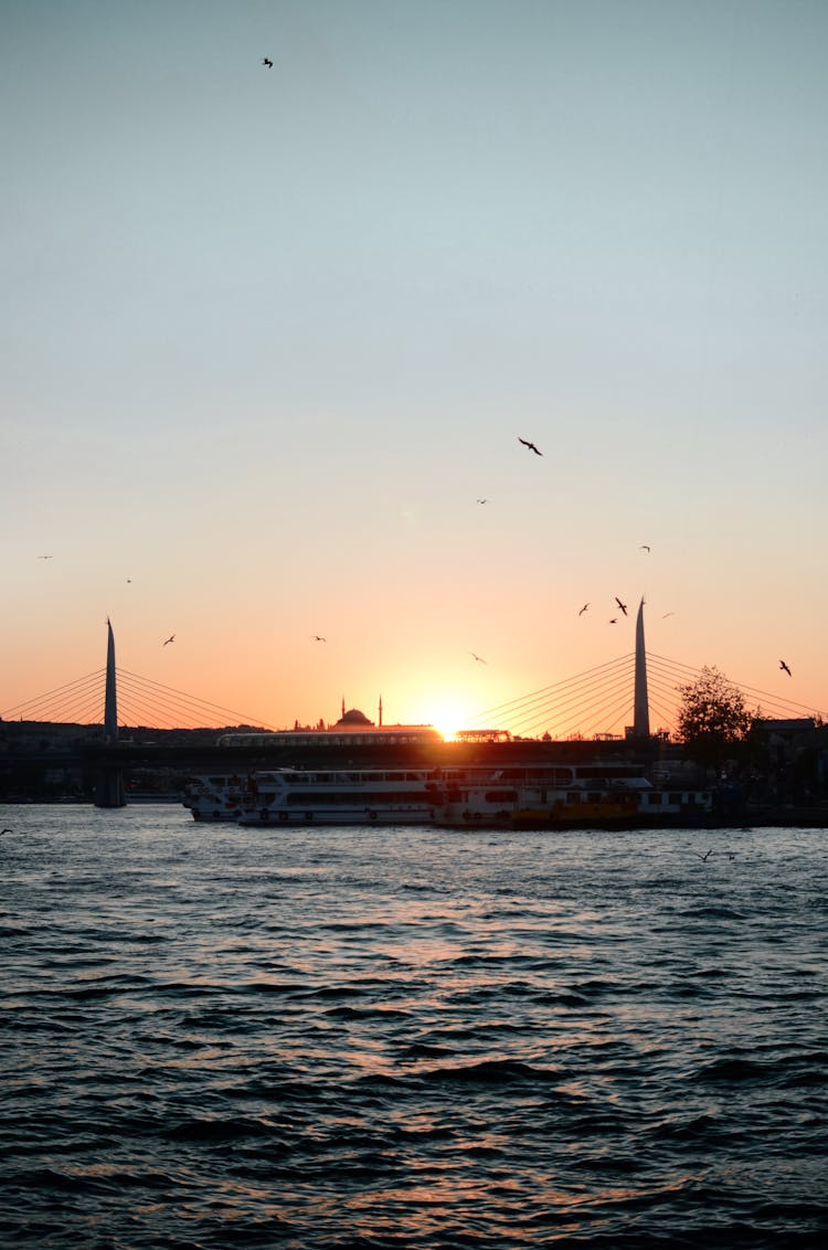 Ship And Bridge On River At Sunset