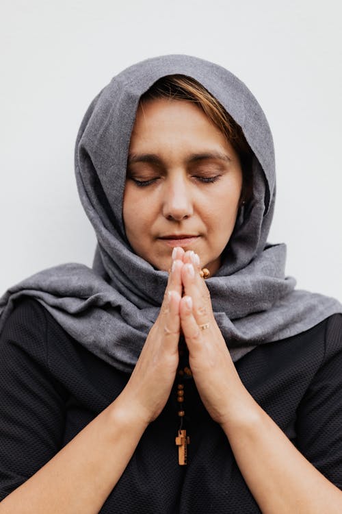 Close-Up Shot of a Woman with Gray Hijab Praying