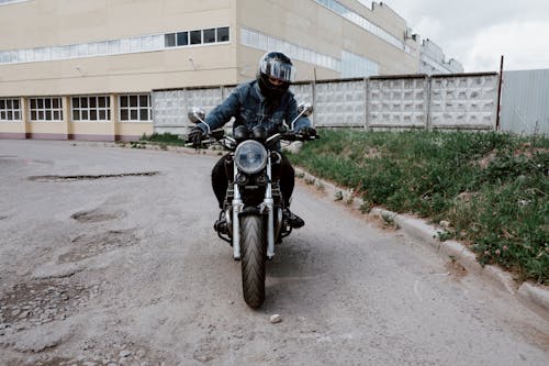 A Man in Black Helmet Riding Black Motorcycle