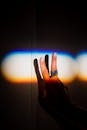 特写镜头中，一只手映衬着彩虹光背景