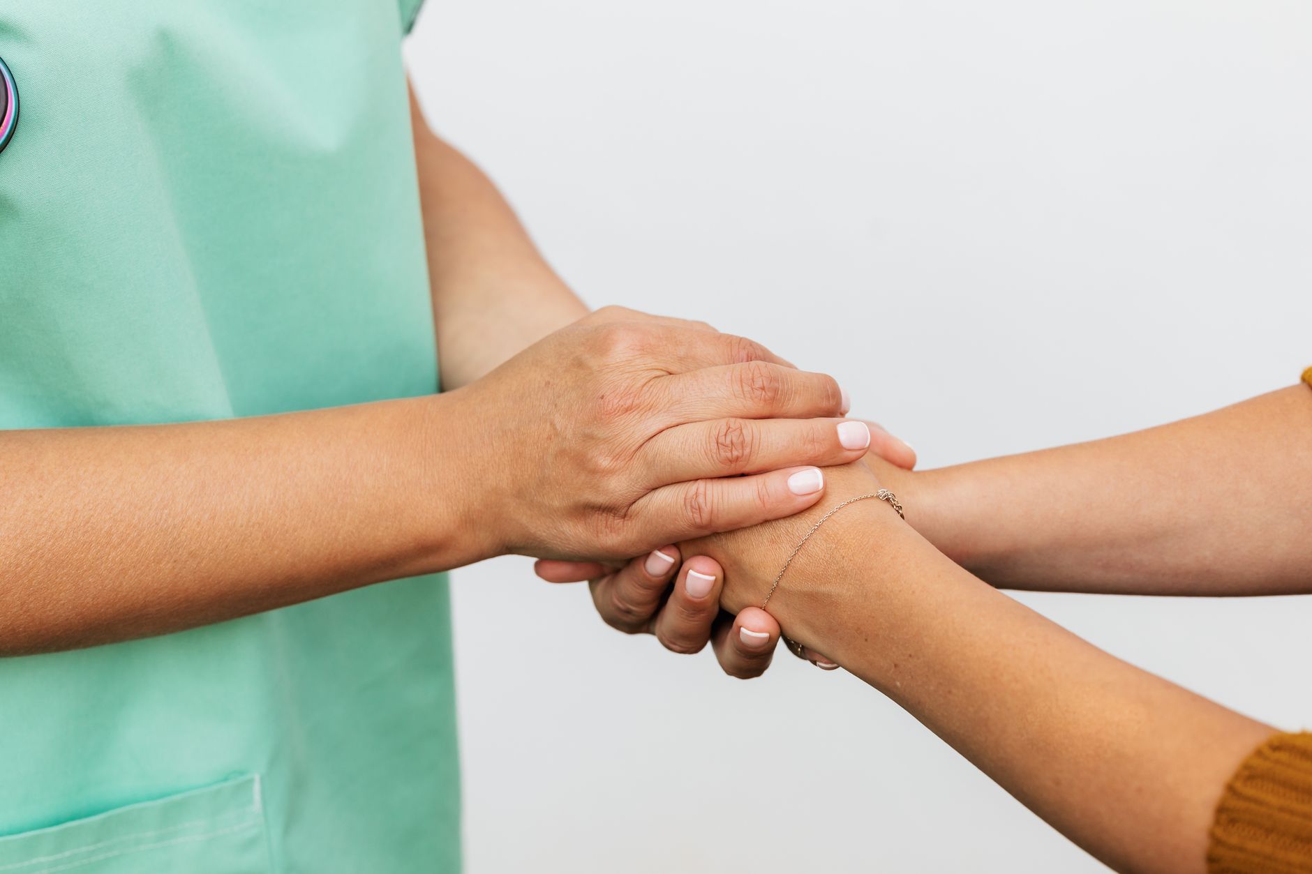 Close-up of two hands showing a supportive gesture, emphasizing care and compassion.