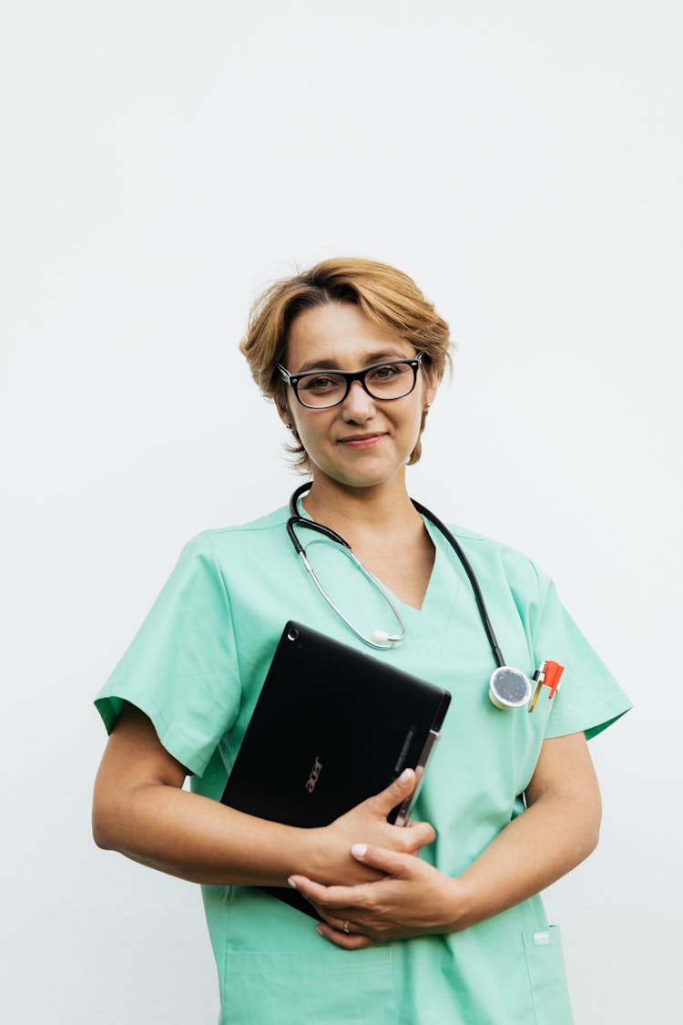 A Woman Wearing Eyeglasses While Holding Laptop