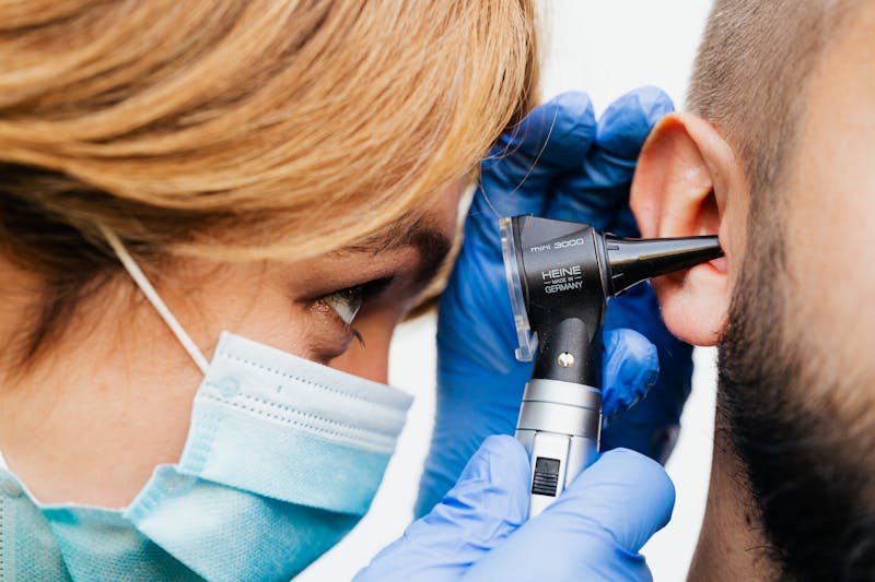 Doctor performing an ear examination at Poorvam Hearing clinic