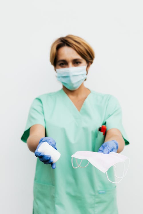 Woman Holding Medicine and Face Mask