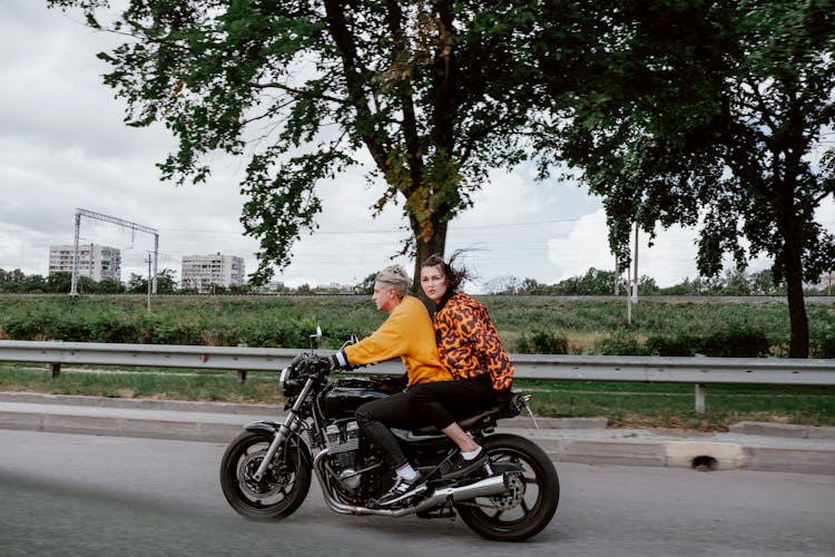 A Man And Woman Riding A Motorcycle Together 