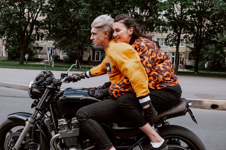 A Couple Riding A Motorcycle Together