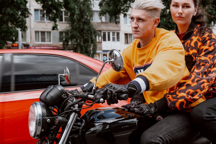 A Couple Riding A Motorcycle Together