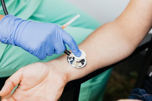 A Nurse Checking the Pulse Using Stethoscope