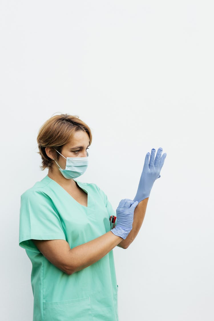 Woman In Scrub Suit Wearing Gloves