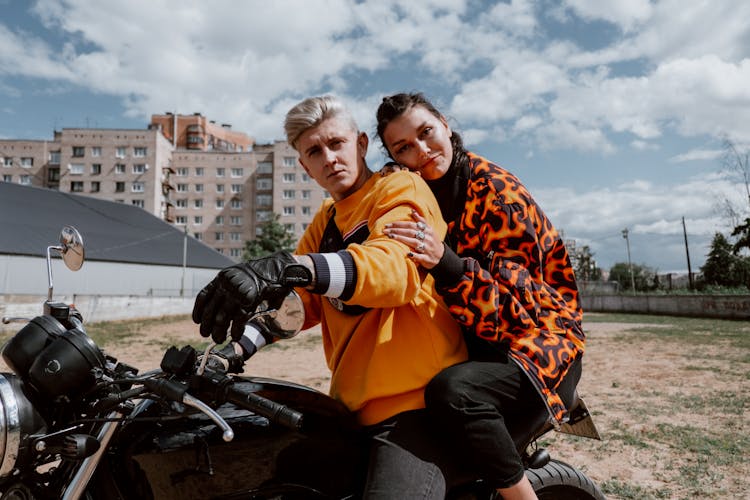 Man In Orange And Black Jacket Sitting On Motorcycle