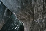 Low angle of abstract textured walls and hanging LED lamps in Salina Turda salt mine in Romania
