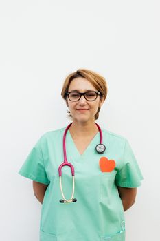 一位穿着绿色手术服、戴着听诊器和眼镜的女医生，自信地站在白色背景前